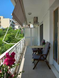 a balcony with a table and chairs and flowers at Hra in Loutraki