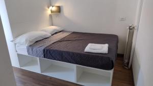 a small room with a bed with a white shelf at Hotel Brioni in Trieste