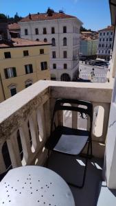 a chair on a balcony with a view of a building at Hotel Brioni in Trieste +91 photos