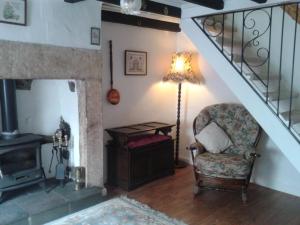 a living room with a chair and a staircase at Angate Cottage in Wolsingham