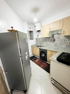 アガディールにあるLuxury Seafront Apartment in Agadir Vue Mer Taghazout Surf & Ocean View your Home placeのステンレス製の冷蔵庫とコンロを備えたキッチン