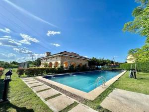 a large swimming pool in front of a house at Travelers Hub 1 Camella Tarlac in Tarlac