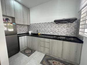 a kitchen with a stove and a refrigerator at Penang Studio Homestay at Kelawai Rd, Georgetown by SK Vacation Homes in George Town
