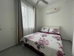 a bedroom with a bed with a floral comforter and a window at Penang Studio Homestay at Kelawai Rd, Georgetown by SK Vacation Homes in George Town