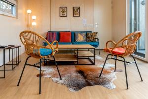 a living room with a couch and two chairs at Huisje123 - Ecohuisjes Terschelling in Midsland
