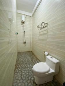 a bathroom with a toilet and a shower at Npdc Comfy Hotel in Toyapakeh