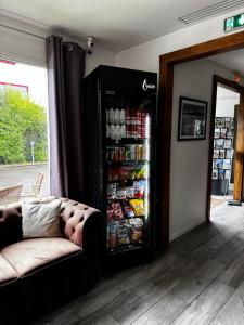 a couch sitting in front of a refrigerator filled with food at Kyriad Lisieux in Lisieux