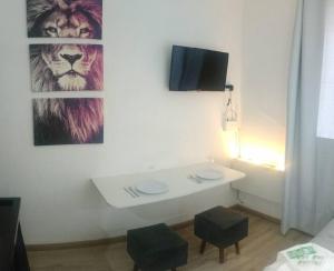 a bathroom with a table and a lion picture on the wall at Apartamento Studio no centro de São Lourenço in São Lourenço