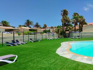 a yard with chairs and a swimming pool at Montes Blancos in Costa Calma