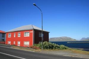 a red building with a street light next to a road at G4 Apartment in Grundarfjordur