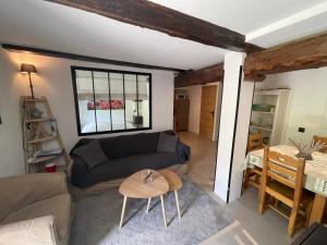 a living room with a couch and a table at LE MONTAGNARD bel appartement avec jardin dans vieille ferme de montagne rénovée in Les Orres