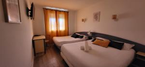 a hotel room with two beds and a window at Hôtel AUSTRIA Style -Ex Nestor Hôtel in Bourg-lès-Valence