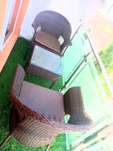 two wicker chairs sitting next to a glass table at The Niche Homes & Apartments in Ikoyi