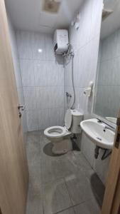 a bathroom with a toilet and a sink at Little Tiny Kingdom Apartemen Jakarta Living Star in Jakarta