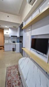 a large living room with a flat screen tv on a wall at Little Tiny Kingdom Apartemen Jakarta Living Star in Jakarta