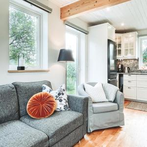 a living room with a couch and a chair at Woodfield Cottage Skåne in Vollsjö