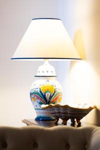 un vase assis au-dessus d'une table avec une lampe dans l'établissement Raffaello - M&M Holiday House, à Pérouse