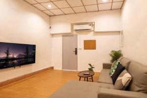 Ban Na Songにある5-BR with 6mins walk to MRT Rama 9のソファと壁掛けテレビのあるリビングルーム