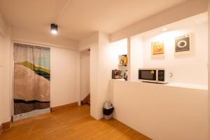 Ban Na Songにある5-BR with 6mins walk to MRT Rama 9の絵が飾られたカウンターの上にテレビがある部屋