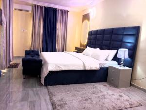 a bedroom with a large bed and a chair at The Niche Homes & Apartments in Ikoyi