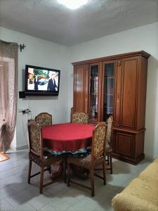 un comedor con una mesa roja y un armario en Civico 149, en Carbonia 9 fotos más