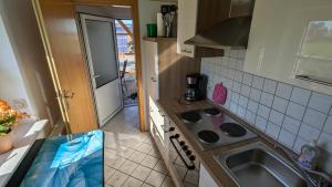 a small kitchen with a sink and a stove at Ferienwohnung Sonja in Westerende +36 photos