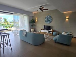 a living room with a blue couch and a tv at Luxury 3 Bedroom Apartment Sea View Azuri Estate in Roches Noires