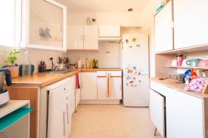 a kitchen with white cabinets and a white refrigerator at Chambre PRIVEE dans charmante maison cosy chez l'habitant in Montpellier +8 photos