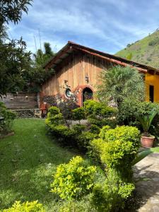 a wooden house with a garden in front of it at Cabañas de Tzununa in Tzununá