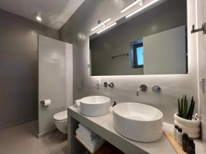 a bathroom with two sinks and a large mirror at Enilio Mera in Sifnos +23 photos