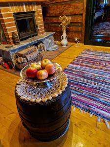 a bowl of apples on a table in a room with a fireplace at Casa Hariton in Drăguş