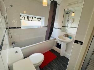 a bathroom with a white toilet and a sink at Contractors families free parking Ramsey Road in St Ives +12 photos