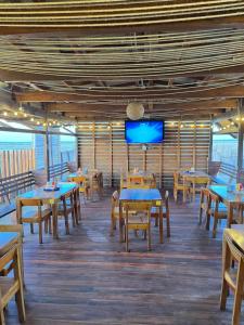 a dining room with tables and a flat screen tv at Vbelasofia in Cabo de la Vela