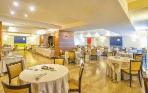 a dining room with white tables and yellow chairs at Virgilio Grand Hotel in Sperlonga