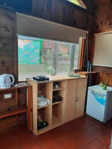 a kitchen with a counter and a refrigerator and a window at Cabaña La iluminada in Tandil