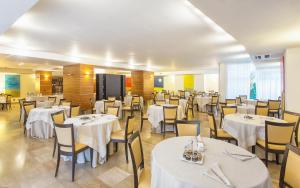 a dining room with white tables and chairs at Virgilio Grand Hotel in Sperlonga