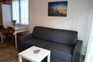 a living room with a couch and a table at LES HIRONDELLES 2KM DE LA PLAGE-JARDIN-WiFi-PARKING-DRAPS ET SERVIETTES in Hendaye