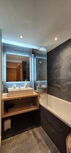a bathroom with a sink and a mirror at Appartement cosy - proche des pistes in La Chapelle-dʼAbondance