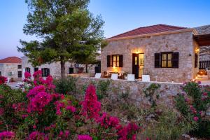 a stone house with pink flowers in front of it at Villa Ftenagia in Halki