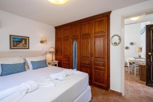 a bedroom with a large white bed with wooden cabinets at Villa Ftenagia in Halki