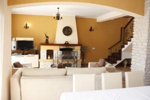 a living room with a white couch and a staircase at Pension Casa Ali & Andu in Buşteni