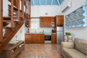 a kitchen with wooden cabinets and a couch in a room at Villa Ftenagia in Halki