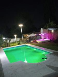 an empty swimming pool at night with a fountain at Cabaña La iluminada in Tandil +6 photos