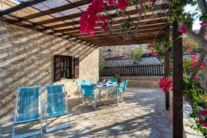 a patio with a table and chairs under a pergola at Villa Ftenagia in Halki