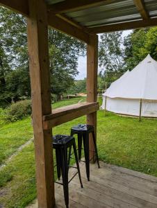 a table and two stools on a porch with a tent at Kestrel lodge in Wrexham