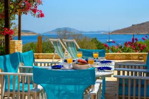 a table with chairs and a table with food and drinks at Villa Ftenagia in Halki
