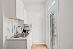 a white kitchen with a sink and a window at Unit # 1 - Right Next to Howard University in Washington