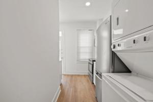 a kitchen with white appliances and a wooden floor at Unit # 1 - Right Next to Howard University in Washington