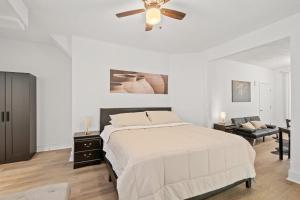 a white bedroom with a bed and a ceiling fan at Unit # 1 - Right Next to Howard University in Washington