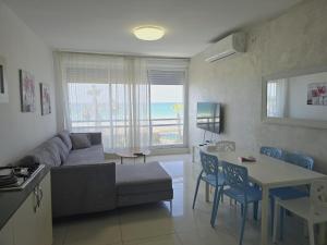 a living room with a couch and a table at GK apartment Beauty in Bat Yam